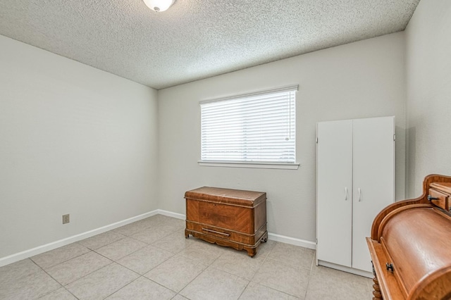 6365 N Barcus Ave, Fresno, CA 93722 - living area featuring a textured ceiling, baseboards, and light tile patterned floors