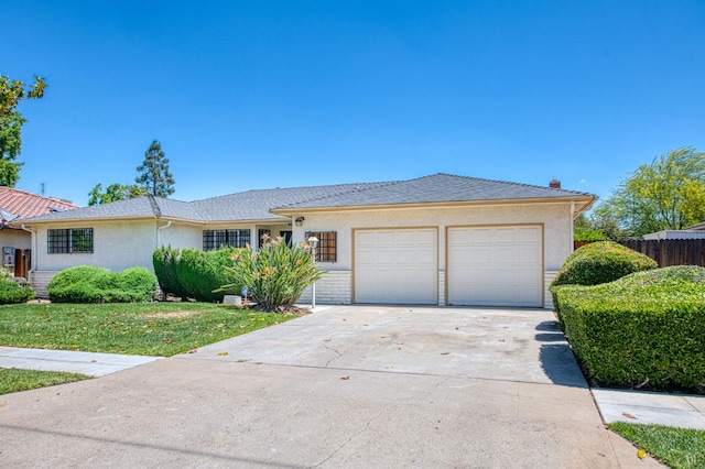 single story home featuring an attached garage, driveway, fence, and stucco siding