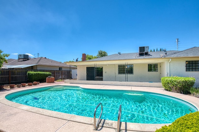 view of swimming pool with cooling unit, fence, and a patio
