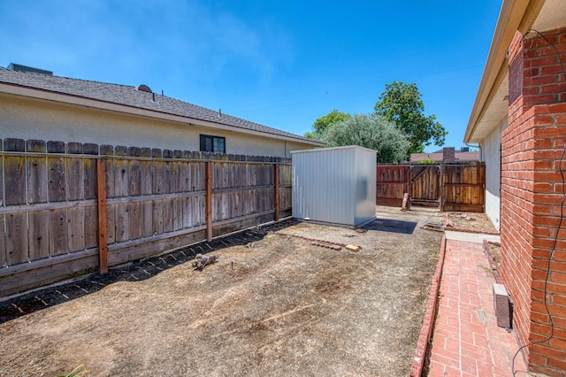 view of patio / terrace featuring a shed, a fenced backyard, and an outbuilding