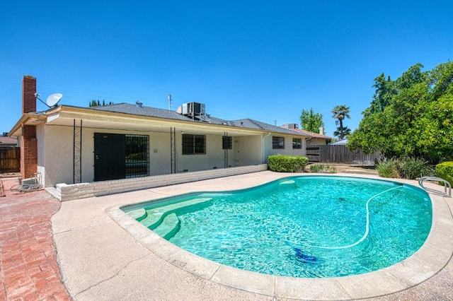 view of pool with a patio, central AC unit, and a fenced backyard