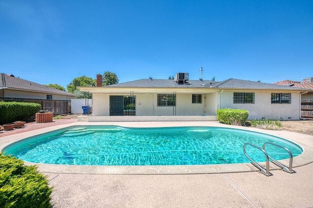 view of pool with a patio, fence, and central AC unit