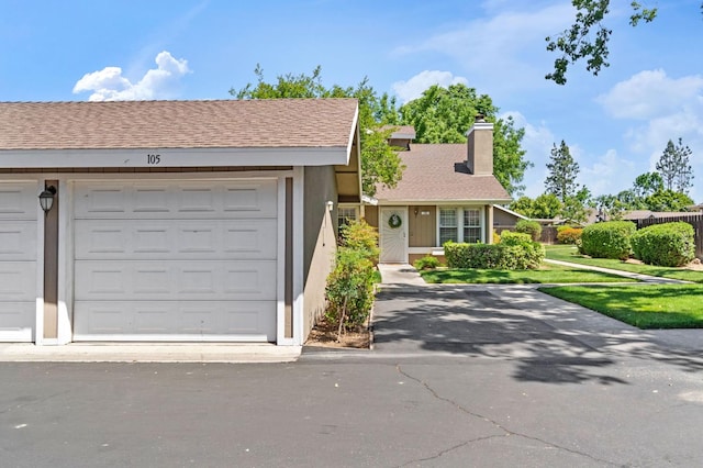 view of front of property with a chimney, stucco siding, and a front yard