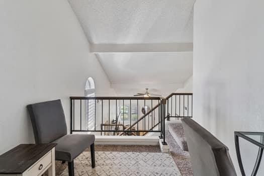 living area featuring a ceiling fan and stairs