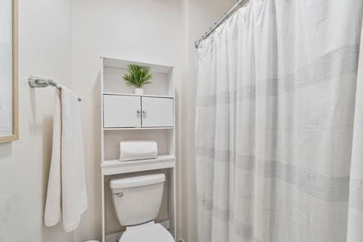 full bath featuring toilet and a shower with curtain