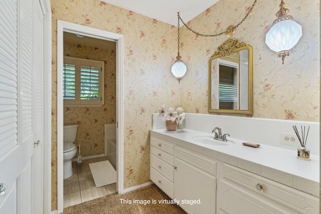 bathroom featuring toilet, a closet, and vanity