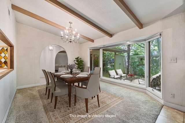 dining space with beamed ceiling, baseboards, a chandelier, arched walkways, and light carpet