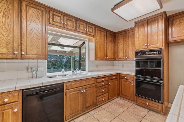 kitchen with black appliances, a sink, decorative backsplash, brown cabinetry, and light tile patterned floors
