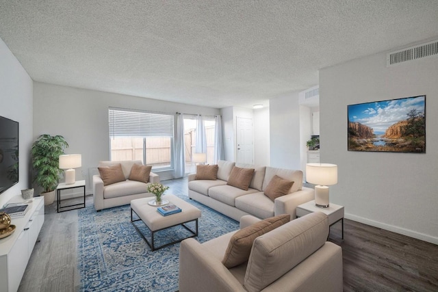 living room featuring wood finished floors, a textured ceiling, and baseboards