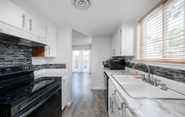kitchen featuring black appliances, under cabinet range hood, a sink, white cabinetry, and light wood-style floors