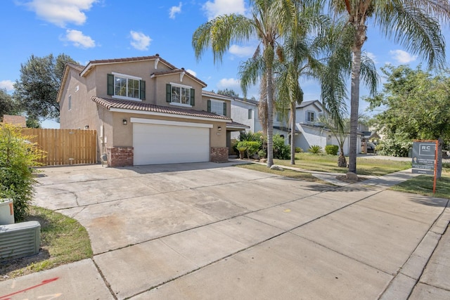 3225 N Mendonca St, Visalia, CA 93291 - view of front of home with stucco siding, concrete driveway, brick siding, a tiled roof, and an attached garage