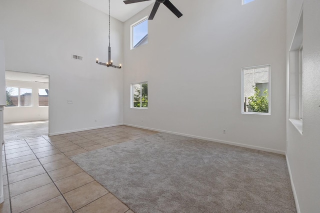 3225 N Mendonca St, Visalia, CA 93291 - unfurnished room with a high ceiling, a ceiling fan, tile patterned flooring, a chandelier, and baseboards