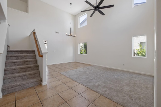 3225 N Mendonca St, Visalia, CA 93291 - unfurnished living room with high vaulted ceiling, light tile patterned flooring, ceiling fan, stairway, and light colored carpet