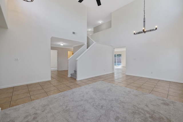3225 N Mendonca St, Visalia, CA 93291 - unfurnished living room featuring tile patterned flooring, a towering ceiling, stairway, a chandelier, and baseboards