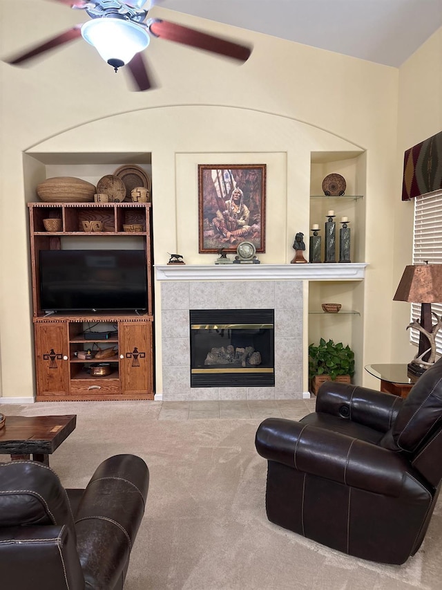 2644 Gibson Ave, Clovis, CA 93611 - carpeted living area with built in shelves, a tiled fireplace, and ceiling fan