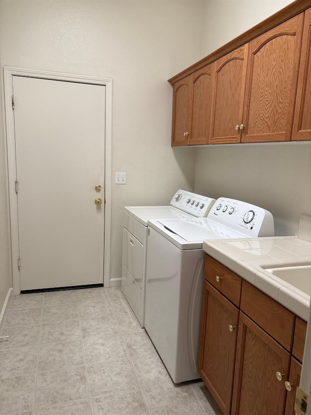 2644 Gibson Ave, Clovis, CA 93611 - clothes washing area with washer and dryer, cabinet space, baseboards, and light tile patterned floors
