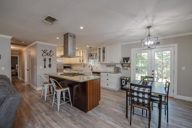 47438 Cheyenne Rd, Coarsegold, CA 93614 - kitchen featuring island exhaust hood, stainless steel appliances, a center island, baseboards, and ornamental molding