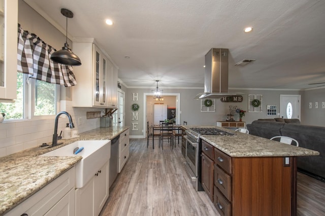 47438 Cheyenne Rd, Coarsegold, CA 93614 - kitchen with island range hood, stainless steel appliances, white cabinets, backsplash, and ornamental molding