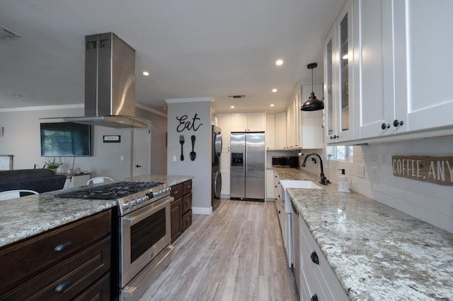 47438 Cheyenne Rd, Coarsegold, CA 93614 - kitchen featuring appliances with stainless steel finishes, island range hood, stacked washer / dryer, white cabinetry, and crown molding