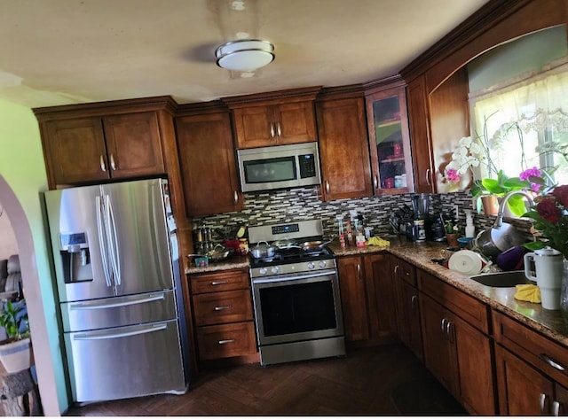 2409 N Valentine Ave, Fresno, CA 93722 - kitchen featuring stainless steel appliances, dark stone countertops, tasteful backsplash, and glass insert cabinets