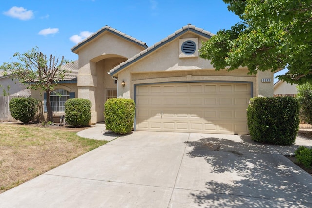 5532 N Cleo Ave, Fresno, CA 93722 - mediterranean / spanish home featuring driveway, stucco siding, an attached garage, and a tiled roof