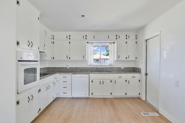 638 W Dennis Dr, Clovis, CA 93612 - kitchen with white appliances, a sink, light wood-style floors, and white cabinets