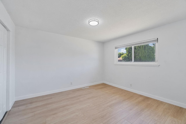638 W Dennis Dr, Clovis, CA 93612 - spare room with light wood-type flooring, baseboards, and a textured ceiling