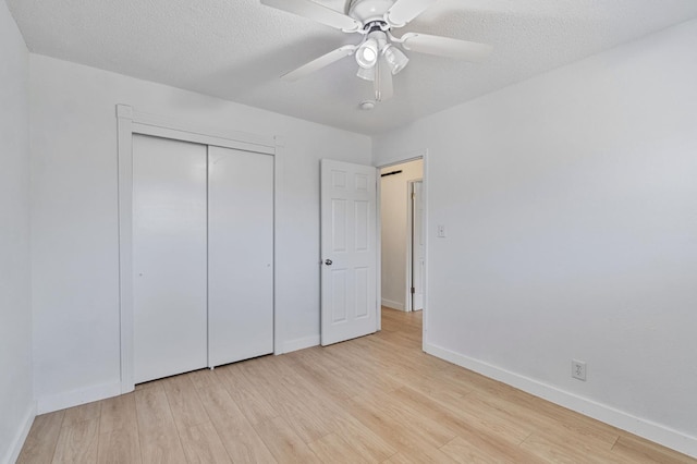 638 W Dennis Dr, Clovis, CA 93612 - unfurnished bedroom featuring light wood-style floors, baseboards, a textured ceiling, and a closet