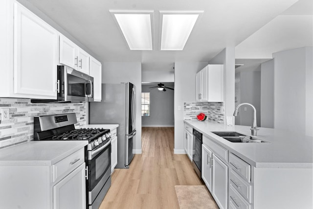 3656 N Laverne Ave, Fresno, CA 93727 - kitchen featuring stainless steel appliances, a sink, backsplash, light wood-type flooring, and light countertops