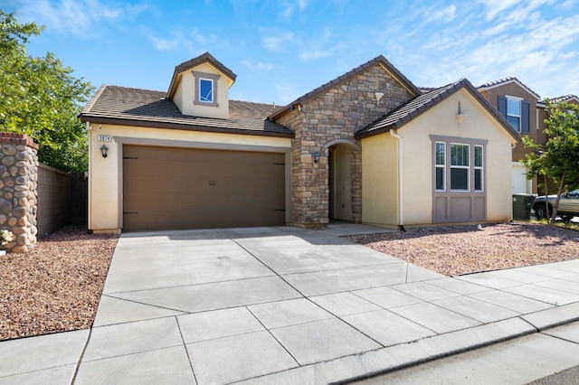 3874 Hampton Way, Clovis, CA 93619 - view of front of home with stucco siding, an attached garage, concrete driveway, a tiled roof, and stone siding