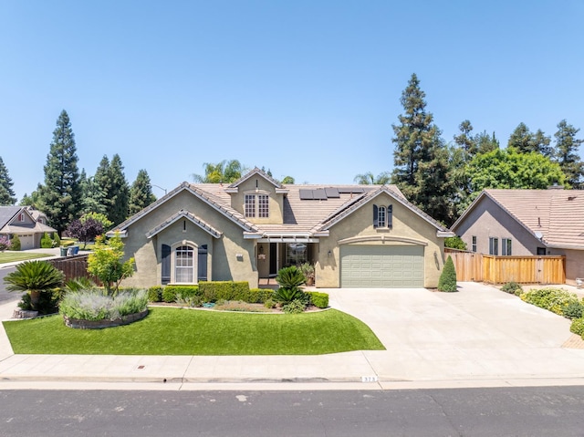 373 W Houston Ave, Clovis, CA 93611 - view of front of property featuring stucco siding, solar panels, concrete driveway, a tile roof, and a garage