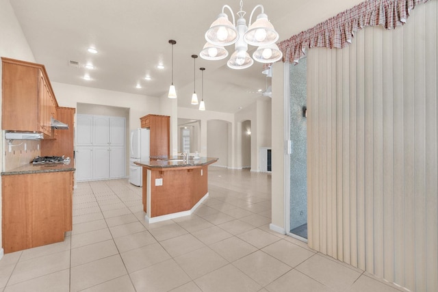 373 W Houston Ave, Clovis, CA 93611 - kitchen with stainless steel gas cooktop, a chandelier, freestanding refrigerator, light tile patterned flooring, and a peninsula