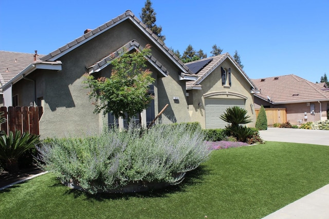 373 W Houston Ave, Clovis, CA 93611 - view of front of property with stucco siding, roof mounted solar panels, concrete driveway, an attached garage, and a tile roof