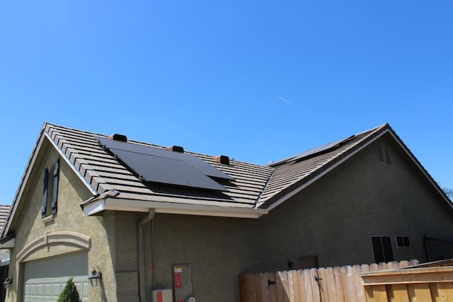 373 W Houston Ave, Clovis, CA 93611 - view of side of home featuring fence, stucco siding, roof mounted solar panels, and a tile roof