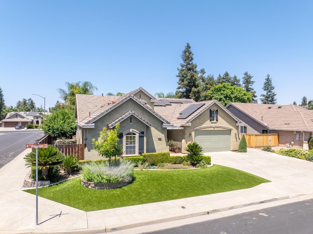 373 W Houston Ave, Clovis, CA 93611 - ranch-style house with stucco siding, solar panels, concrete driveway, a garage, and a tile roof