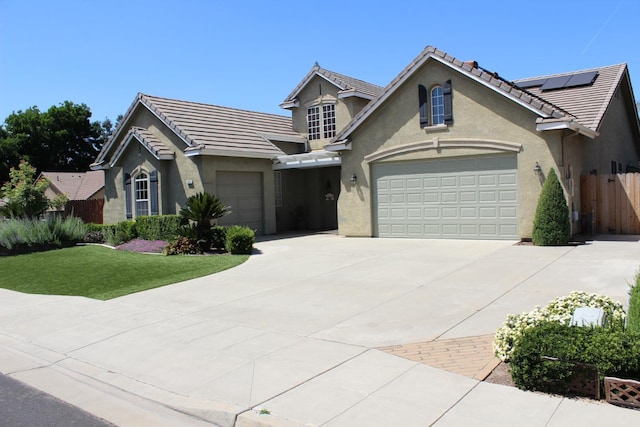 373 W Houston Ave, Clovis, CA 93611 - view of front of home with concrete driveway, a garage, stucco siding, a tile roof, and solar panels