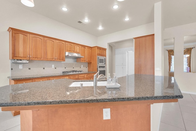 373 W Houston Ave, Clovis, CA 93611 - kitchen featuring appliances with stainless steel finishes, under cabinet range hood, light tile patterned floors, backsplash, and a spacious island