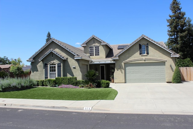 373 W Houston Ave, Clovis, CA 93611 - view of front of property featuring stucco siding, driveway, roof mounted solar panels, an attached garage, and a tiled roof