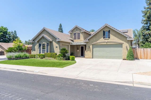 373 W Houston Ave, Clovis, CA 93611 - traditional-style home featuring roof mounted solar panels, concrete driveway, stucco siding, and an attached garage