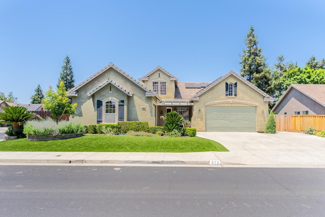 373 W Houston Ave, Clovis, CA 93611 - view of front facade with solar panels, concrete driveway, stucco siding, an attached garage, and a tile roof