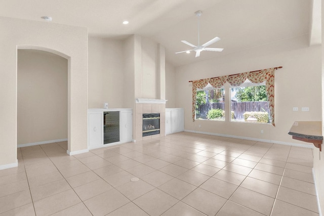373 W Houston Ave, Clovis, CA 93611 - unfurnished living room featuring a ceiling fan, a tile fireplace, light tile patterned floors, arched walkways, and recessed lighting