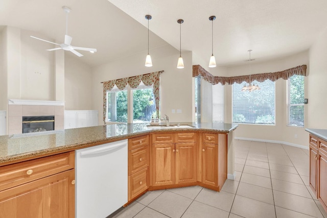 373 W Houston Ave, Clovis, CA 93611 - kitchen with dishwasher, a ceiling fan, light tile patterned flooring, a tiled fireplace, and light stone counters