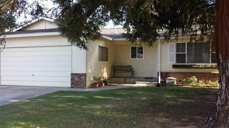 3415 W Oswego Ave, Fresno, CA 93711 - view of front of home with a garage, driveway, a front lawn, and stucco siding