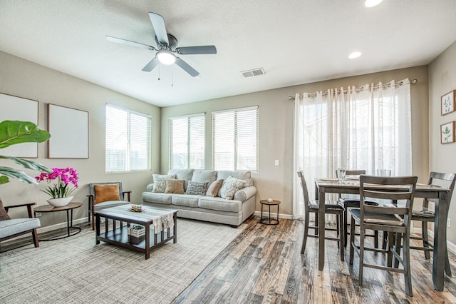 living area featuring a ceiling fan, baseboards, wood finished floors, and recessed lighting