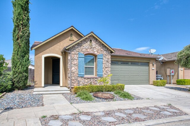 view of front of property featuring stone siding, stucco siding, an attached garage, and driveway