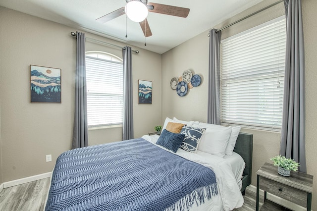 bedroom featuring wood finished floors, baseboards, and ceiling fan