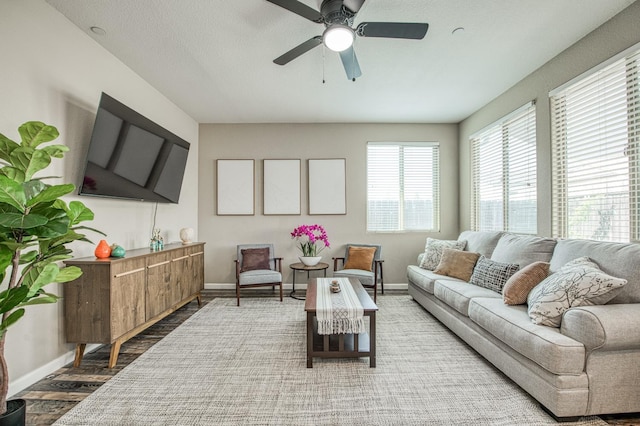 living room featuring baseboards, wood finished floors, and ceiling fan