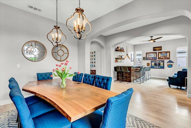 2315 W Malone St, Hanford, CA 93230 - dining area with a chandelier, wood finished floors, arched walkways, and a ceiling fan