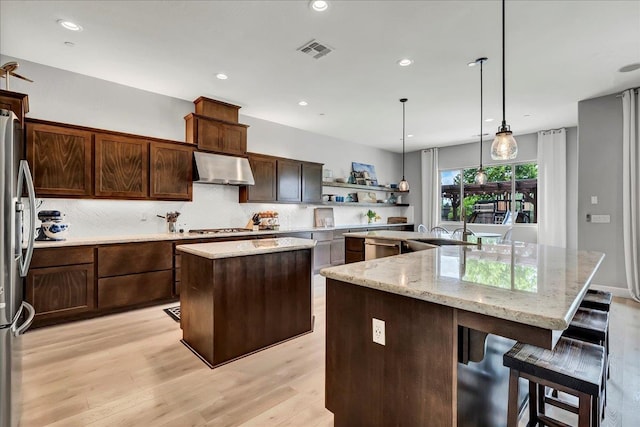 2315 W Malone St, Hanford, CA 93230 - kitchen with a kitchen island with sink, under cabinet range hood, a sink, decorative backsplash, and recessed lighting