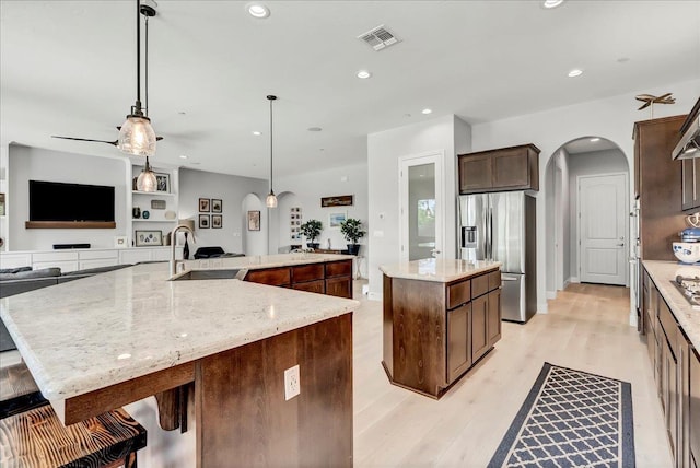 2315 W Malone St, Hanford, CA 93230 - kitchen with stainless steel refrigerator with ice dispenser, a large island, a sink, arched walkways, and open floor plan
